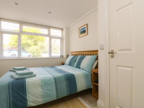 a bedroom with a bed and a window at Seascape in Porthcurno