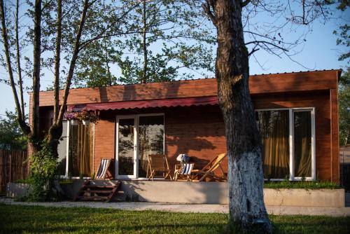 una pequeña casa con mecedoras en el porche en Cottages in Kaprovani "Family nest" en Ureki