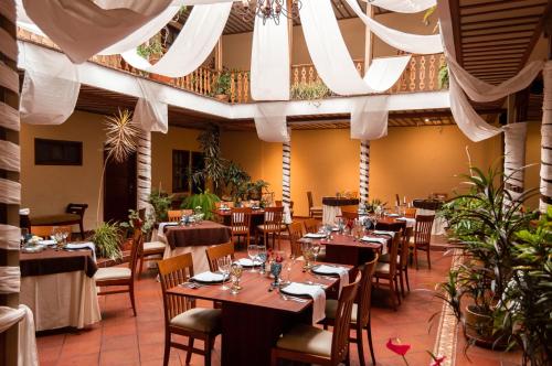 a restaurant with tables and chairs in a room at Hotel Carvallo in Cuenca