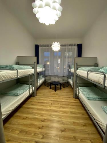 a room with four bunk beds and a chandelier at SKY HOSTEL in Krakow