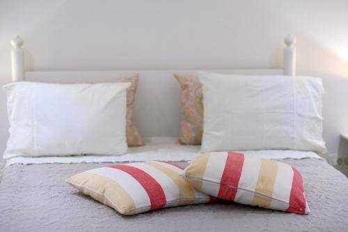 a bed with red and white pillows on it at On the Rock Apartments in Šibenik