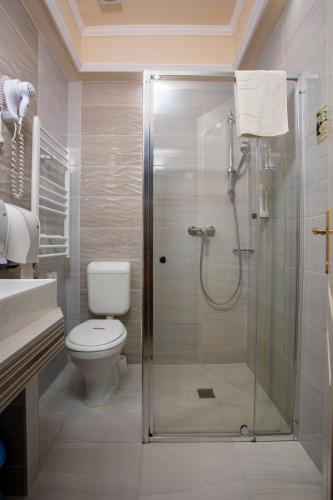 a bathroom with a shower with a toilet and a sink at Illés Hotel in Szeged