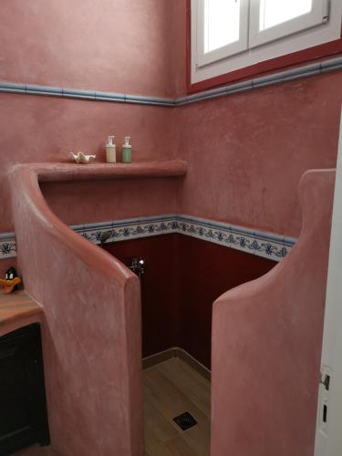 a bathroom with a red wall and a stairway at Aegean Blue Icons in Foinikiá