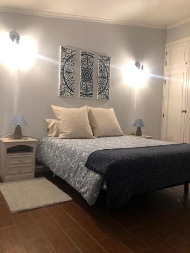 a bedroom with a bed with two lamps and two tables at Casa da Encosta Douro Valley in Pinhão