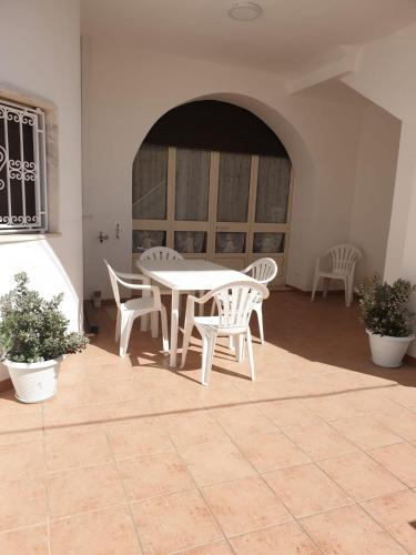 - une table et des chaises blanches dans la chambre dans l'établissement ONDA AZZURRA - PIANO TERRA, à Torre San Giovanni