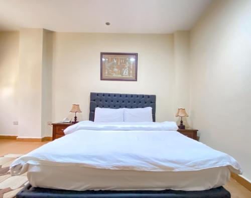 a bedroom with a large bed with white sheets at Best View Pyramids Hotel in Cairo