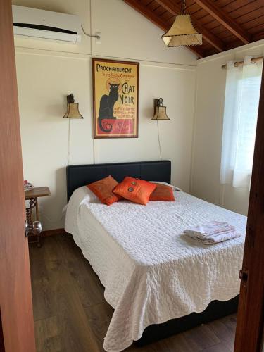 a bedroom with a bed with orange pillows on it at Cabaña Punta Negra in Punta Colorada
