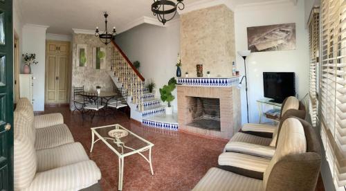 sala de estar con muebles blancos y chimenea en Airam house, en Mazagón
