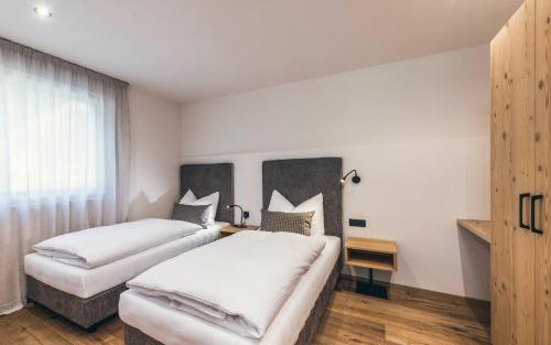 Habitación de hotel con 2 camas y sofá en Lichtung Woldererhof Sonnenlicht, en Casateia
