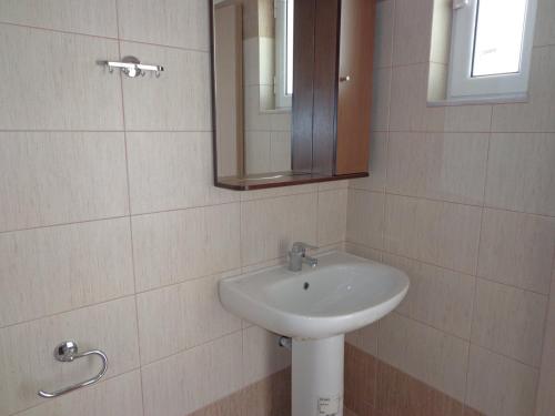 a bathroom with a sink and a mirror at Akti Zaga Apartments in Koroni