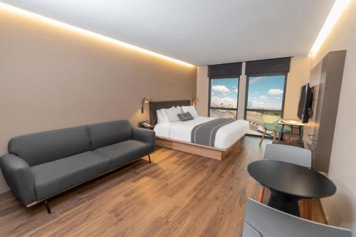 a hotel room with a bed and a couch at Highland Chihuahua in Chihuahua