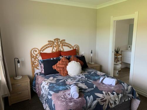 a bedroom with a bed with pillows on it at Brixton farm stay in Waitara