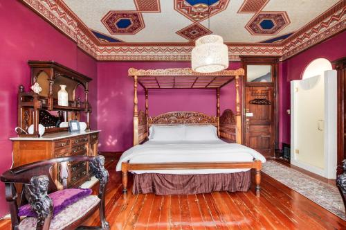 a bedroom with a bed and purple walls at Lumber Baron Inn and Gardens in Denver