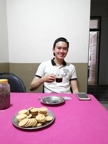 a man sitting at a table with a plate of cookies at david hostel in Aswan