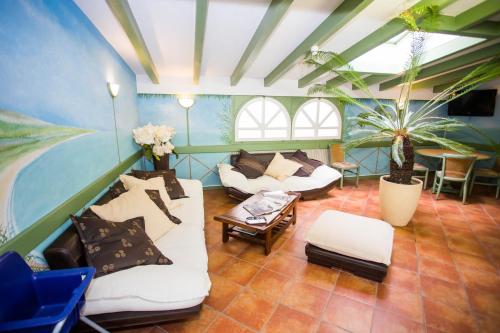 a living room with two couches and a table at Hôtel du Port in Villeneuve