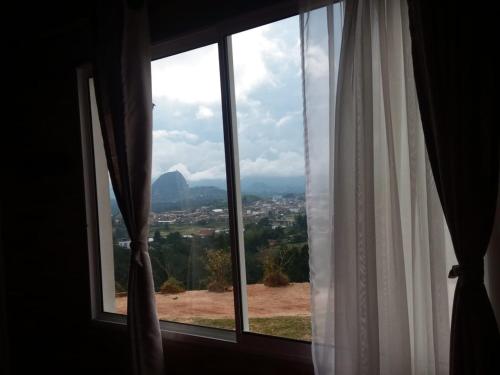 a window with a view of a mountain at El Mirador de Guatape APTO in Guatapé