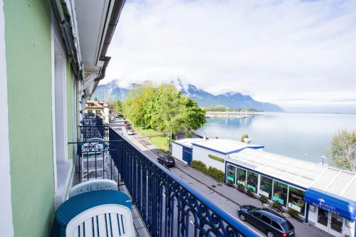 a balcony of a building with a view of the water at Hôtel du Port in Villeneuve