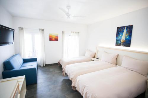 a hotel room with two beds and a blue chair at Hôtel du Port in Villeneuve