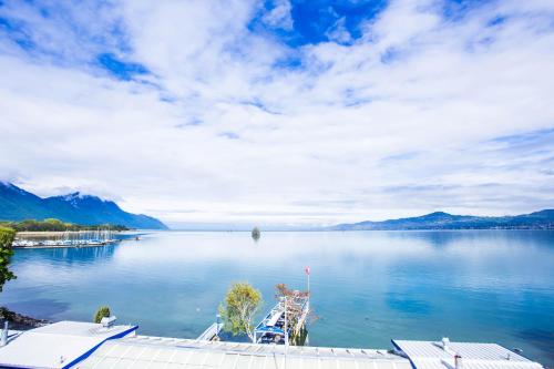 a large body of water with a boat in it at Hôtel du Port in Villeneuve