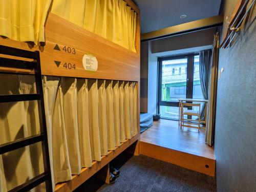 a locker room with yellow curtains and a window at Grids Tokyo Ueno Hotel&Hostel in Tokyo