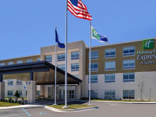 a hotel with two flags in front of a building at Holiday Inn Express & Suites - Brighton South - US 23 by IHG in Brighton