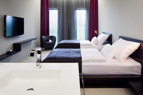 a hotel room with two beds and a tv at Miura Hotel in Čeladná