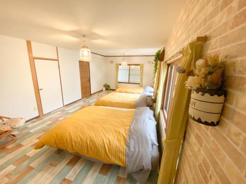a bedroom with two beds with yellow sheets at Shionoyu Onsen 汐の湯 モール温泉付き in Shiraoi