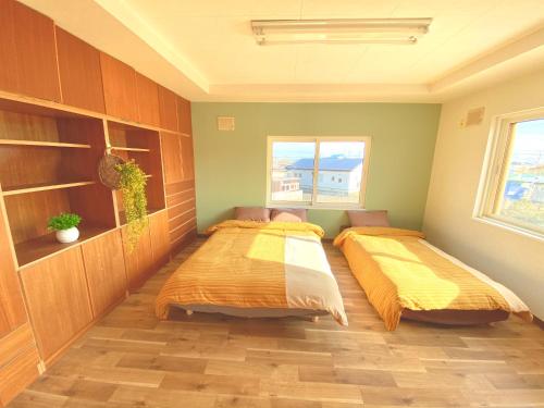 two beds are in a room with at Shionoyu Onsen 汐の湯 モール温泉付き in Shiraoi