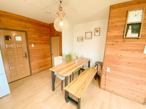 a dining room with a table and a wooden wall at Shionoyu Onsen 汐の湯 モール温泉付き in Shiraoi