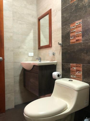 a bathroom with a toilet and a sink at Hotel Arena Blanca in Salinas