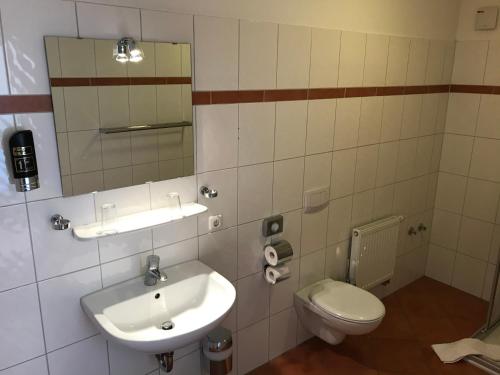 a bathroom with a sink and a toilet at Hotel Hennies Hannover Sehnde in Hannover