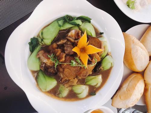 a bowl of soup with a flower on top of it at Vincent Halong Hotel in Ha Long