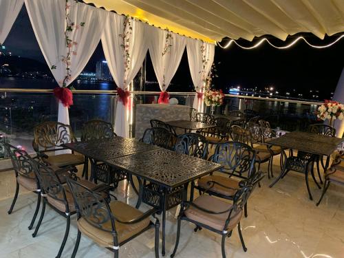 a restaurant with tables and chairs and a view of the city at Vincent Halong Hotel in Ha Long