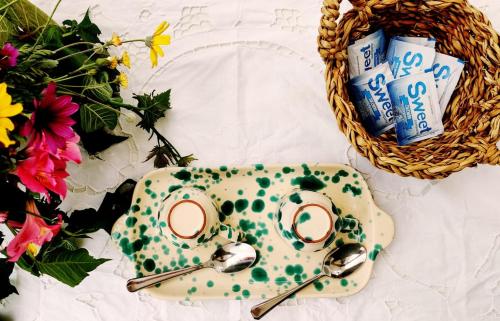a plate with two spoons and a basket of flowers at MAREULIVI in Ostuni