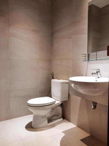 a bathroom with a toilet and a sink at Votel Krakatau Boutique Hotel Semarang in Semarang