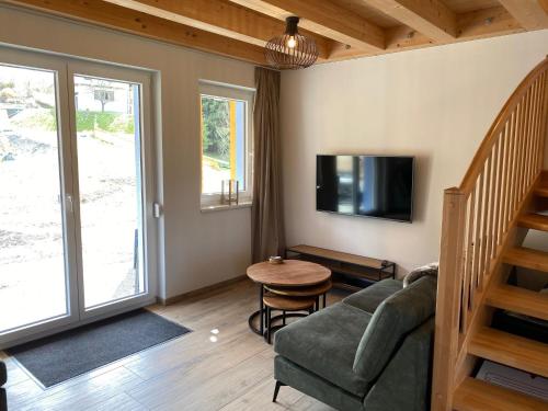 a living room with a couch and a table at Casa Blu Kärnten - One Holiday in Three Countries - Cold&Hottub, Sauna - Piste in Arnoldstein