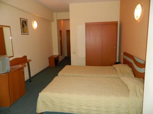 a hotel room with two beds and a desk at Elizeu Hotel in Bucharest