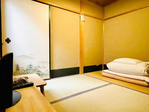 Habitación pequeña con cama y ventana en Nagomi-Ryokan Yuu, en Kioto