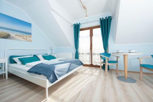 a bedroom with a bed and a table and chairs at Jaśmin in Rowy