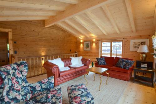 a living room with red furniture and wooden walls at Chalet Kaisereck in Reit im Winkl