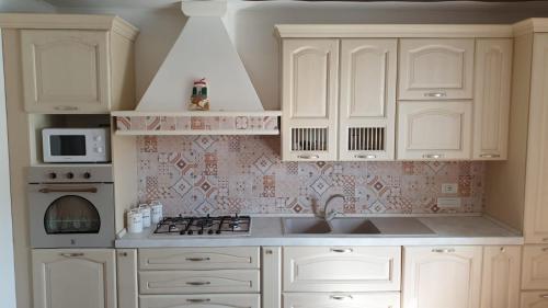 a kitchen with white cabinets and a sink and a stove at Donna Caterì in Termini
