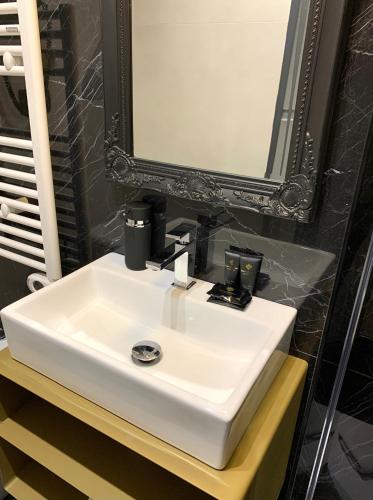 a white sink in a bathroom with a mirror at Toledo Boutique Rooms in Naples
