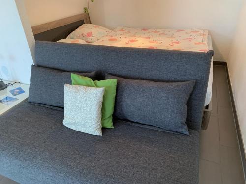 una cama con almohadas sentadas encima de ella en C&C Eco Studio, en La Sonnaz