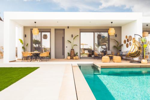 une villa avec une piscine et un coin repas dans l'établissement Nagia Luxury Family Villas, à Analipsi