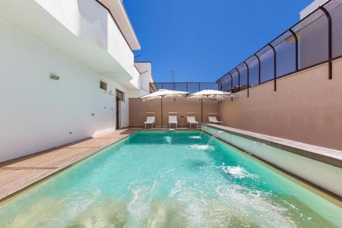 una piscina en medio de un edificio en Joy Home Apartments by BarbarHouse, en Maruggio