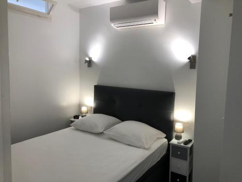 ein Schlafzimmer mit einem weißen Bett mit zwei Kissen in der Unterkunft APPARTEMENT TERRASSE VUE MER Sea view terrace apartment "Etoile de Mer" in Menton