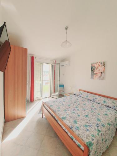 Schlafzimmer mit einem Bett und einem Fenster in der Unterkunft Affittacamere Sofy in Villasimius