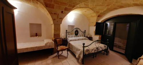 a bedroom with two beds in a stone room at Masseria San Nicola B&B in Torre Santa Susanna