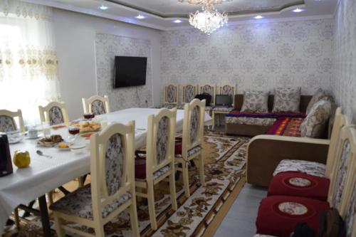 a dining room with a table and chairs and a couch at Naryn Guest House in Naryn