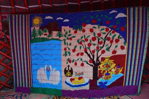 a quilt with a tree and fruits on it at Naryn Guest House in Naryn